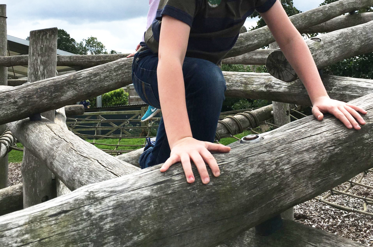 Child climbing on a wooden sructure